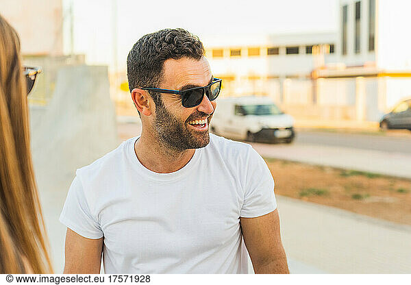 Attractive man in white t-shirt smiling glasses speaks animatedly