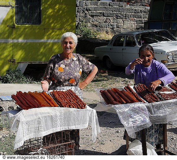 Außerhalb des Klosters Geghard (armenisches Weltkulturerbe) verkaufen alte Frauen Obst sujukh. Er wird aus geschälten Walnüssen hergestellt  die in Traubensirup getaucht werden  bis sie eine dicke und zarte Schicht bilden. Armenien.