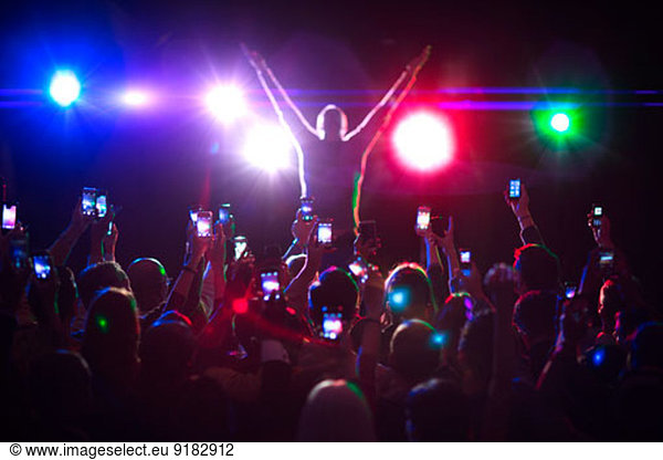 Audience photographing musician on stage
