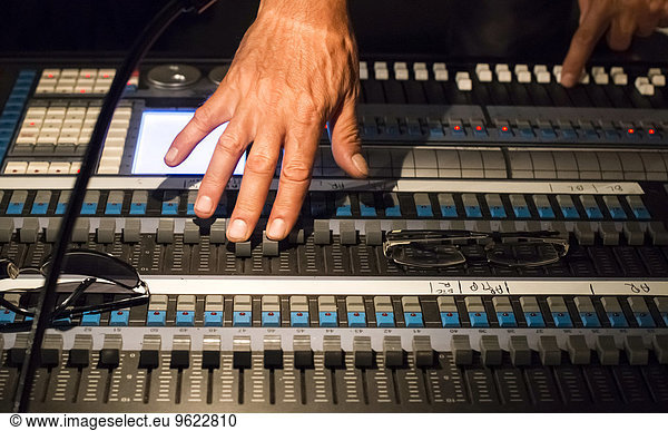 Audio engineer's hands at mixing console