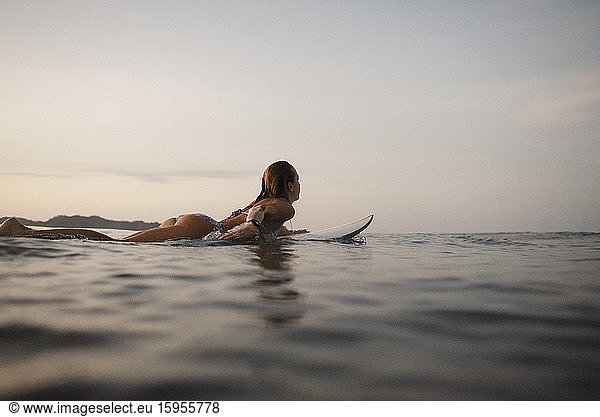Auf einem Surfbrett liegender weiblicher Surfer  Costa Rica