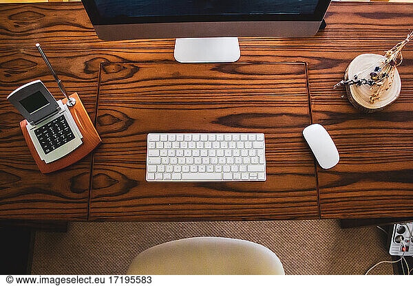 Aufnahme eines Tischcomputers mit Maus und Tastatur auf einem Holztisch