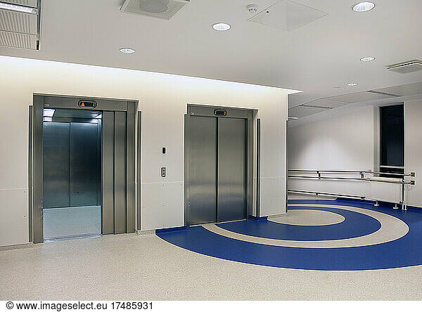 Aufzüge im Atrium eines neuen modernen Krankenhauses  blaue Muster auf dem Boden