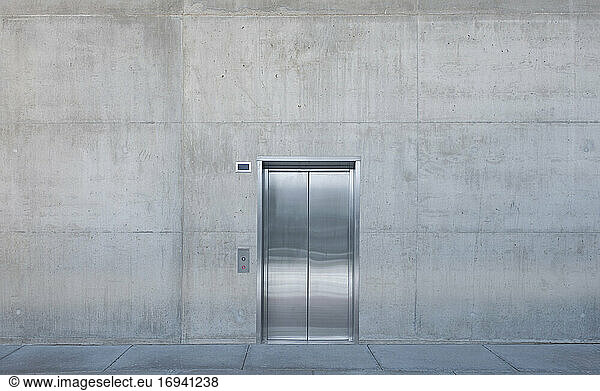 Aufzugstüren aus Metall in einer Betonwand.