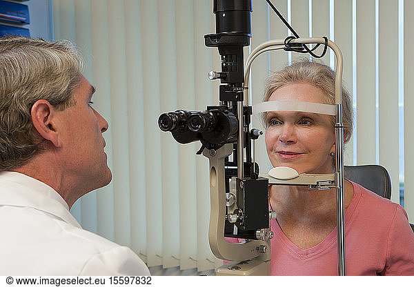 Augenarzt bei der Untersuchung der Augen einer Frau mit einer Spaltlampe