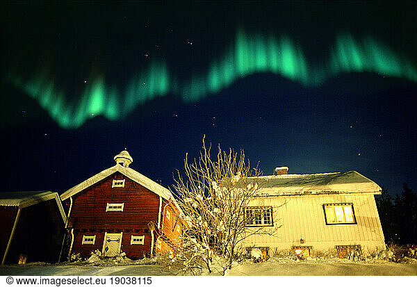 Aurora borealis over traditional house