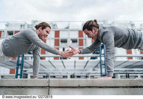 Ausbildung junger erwachsener männlicher Zwillinge  die einarmige Liegestützen machen