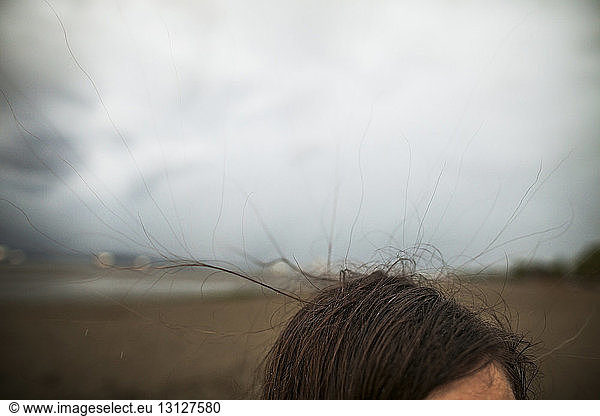 Ausschnitt einer Frau im Strandpark Spanish Banks vor bewölktem Himmel