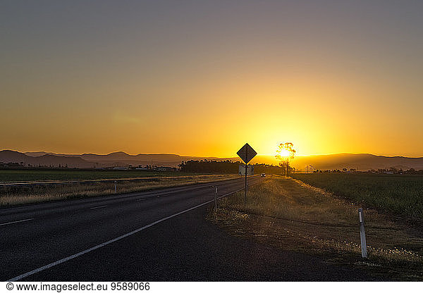 Australia  Queensland  road with mountain chain at sunrise