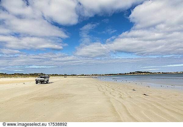 Australia South Australia Robe Summer clouds over car driving along Fox Beach