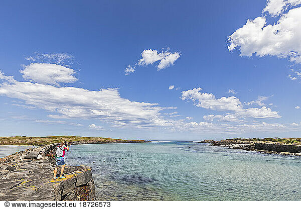 Australia  Victoria  Port Fairy  Female tourist taking photos in Port Fairy Coastline Protection Reserve