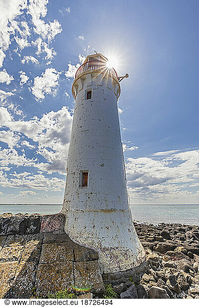 Australia  Victoria  Port Fairy  Rocky beach and Port Fairy Lighthouse in summer
