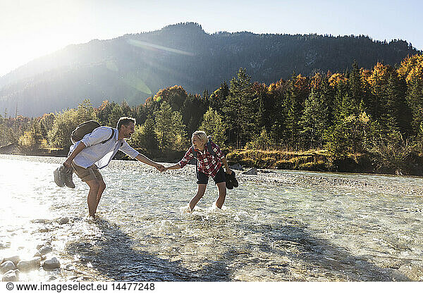 Austria  Alps  couple on a hiking trip wading in a brook