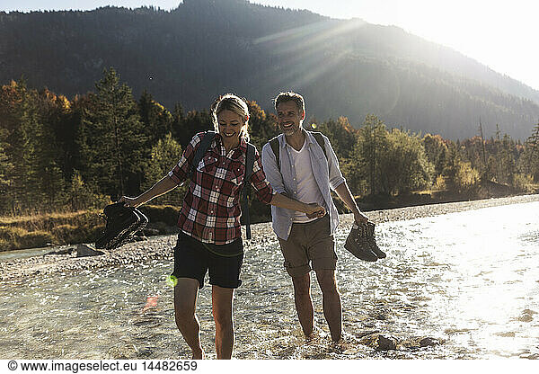 Austria  Alps  couple on a hiking trip wading in a brook