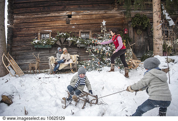 Austria  Altenmarkt-Zauchensee  family in front of farmhouse at Christmas time