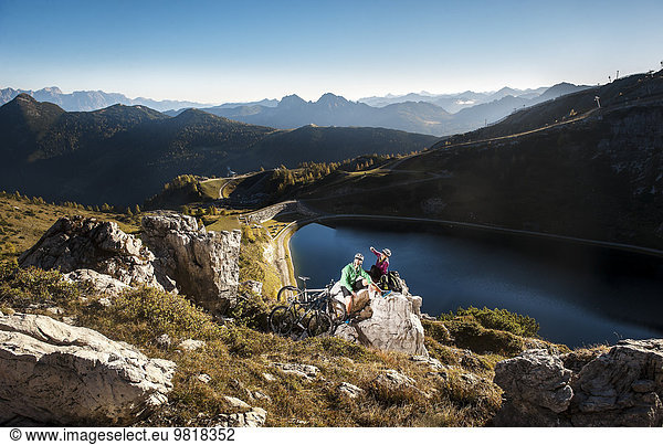 Austria  Altenmarkt-Zauchensee  young couple with mountain bikes in the mountains