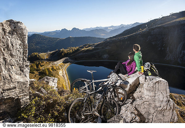Austria  Altenmarkt-Zauchensee  young couple with mountain bikes in the mountains