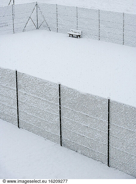 Austria  Styria  Bench and fence covered with snow at tennis court