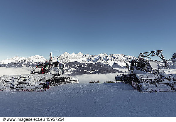 Austria  Styria  Schladming  Clear sky over two snowplows and Dachsteinmassiv