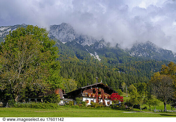 Austria  Tirol  Clouds over farmhouse in Kaiser Mountains