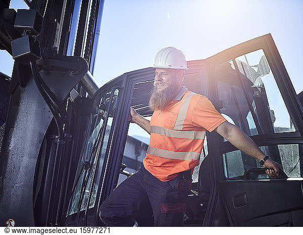 Austria  Tyrol  Brixlegg  Construction worker wearing reflecting clothing and hardhat standing by vehicle