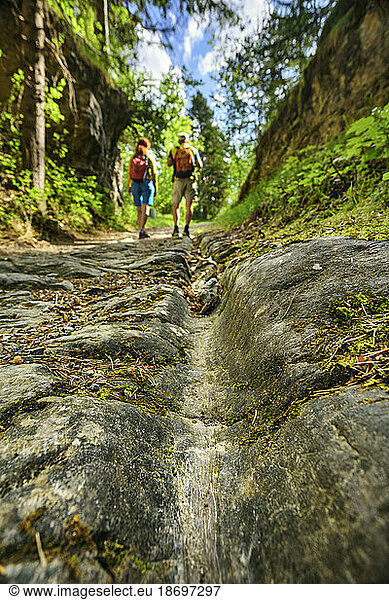 Austria  Tyrol  Hiking pair walking along ancient Roman road Via Augusta