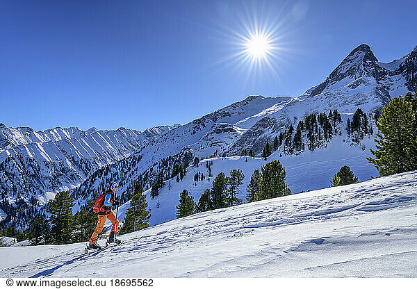 Austria  Tyrol  Sun shining over female skier at Torhelm mountain