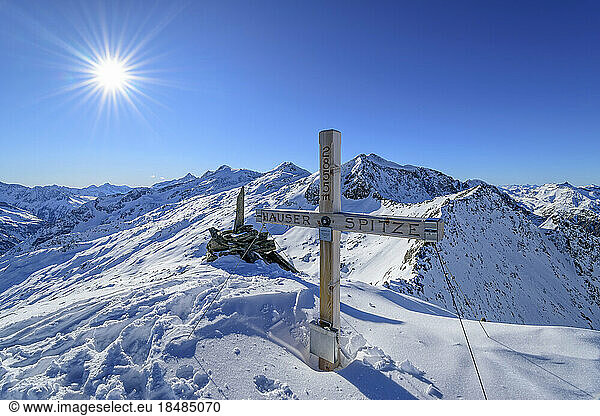 Austria  Tyrol  Sun shining over summit cross in Zillertal Alps