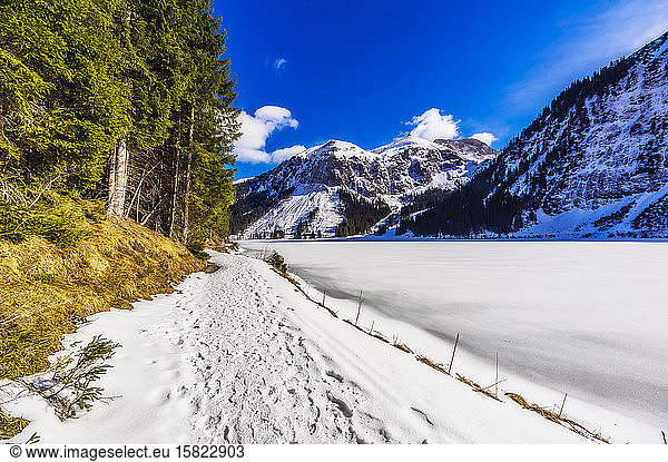 Austria  Tyrol  Tannheim  Snowy footpath stretching along shore of frozen Vilsalpsee lake
