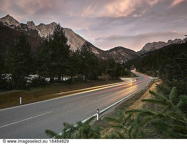 Austria  Vehicle light trails stretching along country road at dusk