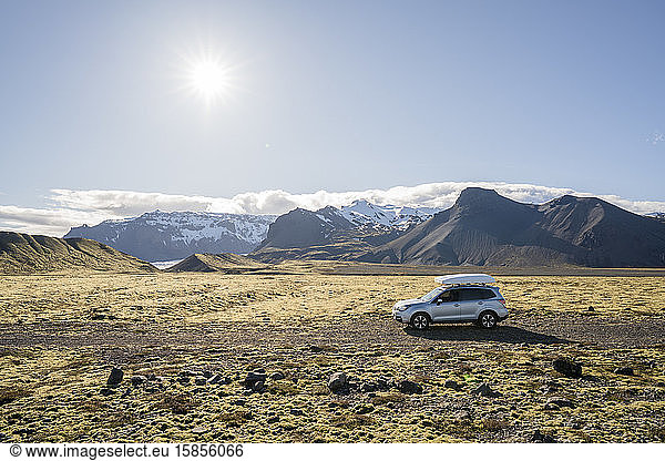 Autofahren auf Schotterstraße mit Bergen dahinter  in Island