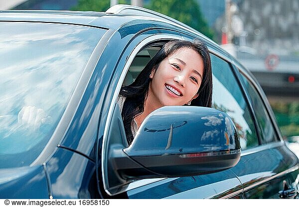 Autofahren Junge Frauen lehnen sich mit dem Kopf aus dem Fenster