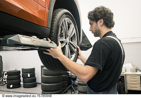 Automechaniker in einer Werkstatt beim Reifenwechsel