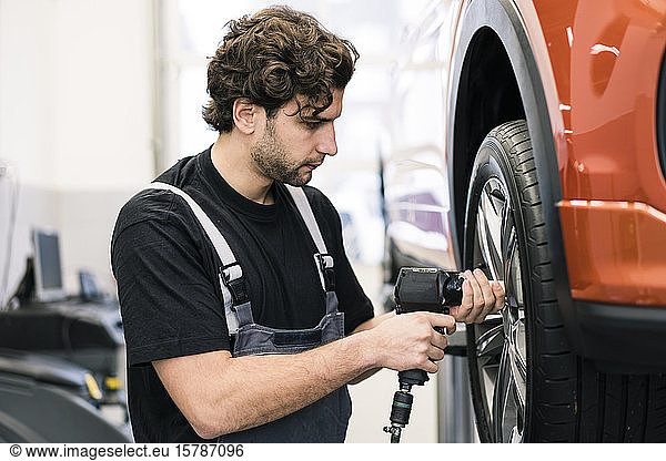 Automechaniker in einer Werkstatt beim Reifenwechsel