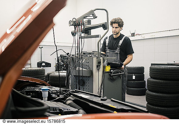 Automechaniker in einer Werkstatt mit moderner Diagnoseausrüstung