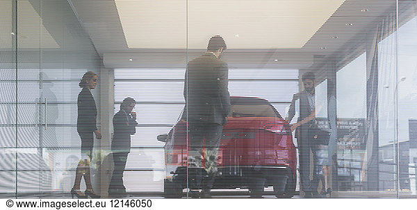 Autoverkäufer und Kunden  die ein neues Auto im Autohaus suchen