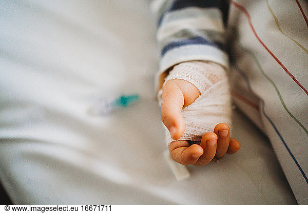 Baby child hand with IV sick at the hospital with a virus coronavirus