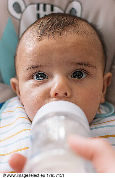 Baby drinking milk from a feeding bottle.
