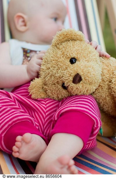 Baby girl holding teddy bear