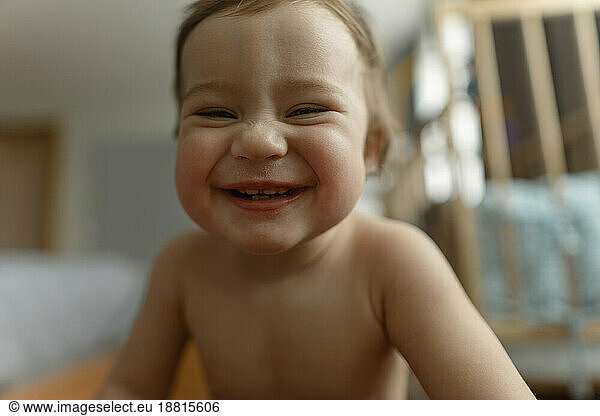 Baby girl laughing in bedroom