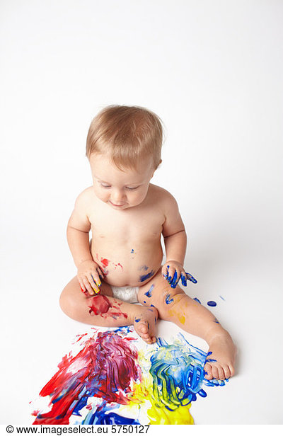 Baby looking at messy paint