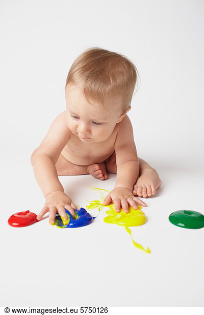 Baby putting hands in finger paints