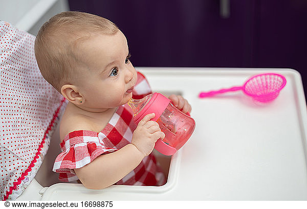 Baby trinkt Wasser aus seiner Flasche