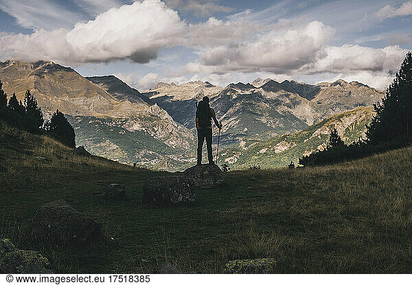 Back view of a young hiker looking at the high mountains  Pyrenees.