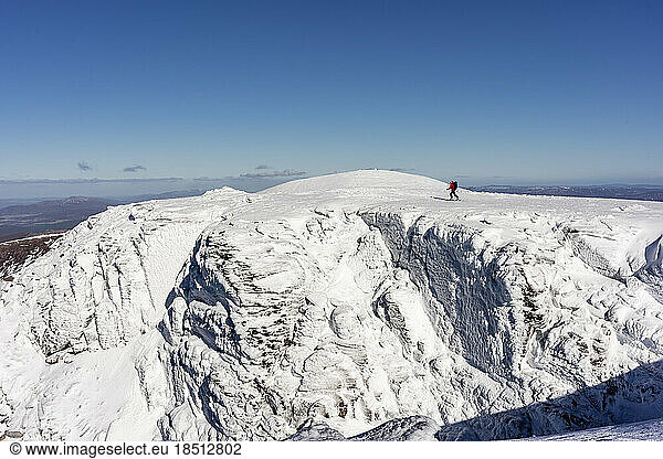 Backcountry Skier above snow-covered cliffs