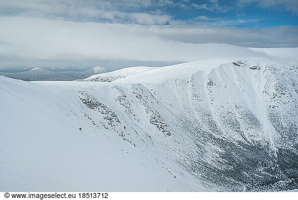 Backcountry skier skiing snow field on wide open mountain