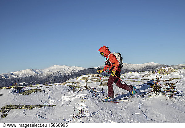 Backcountry skier skins across summit of Baldface  NH Mount Washington