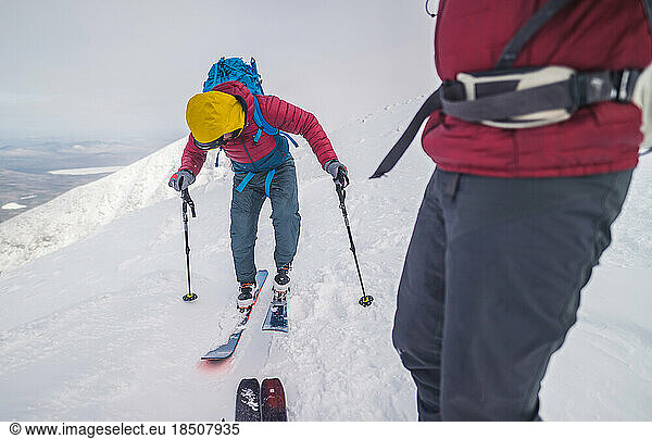 Backcountry skiers checking their equiment before beginning descent