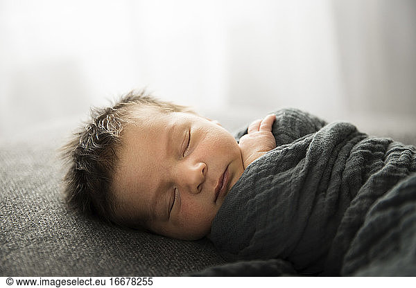 Backlit Sleeping Newborn With Lots of Hair Faces Camera