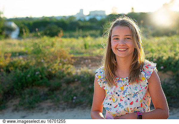 Backlit Smiling Girl in a summer dress